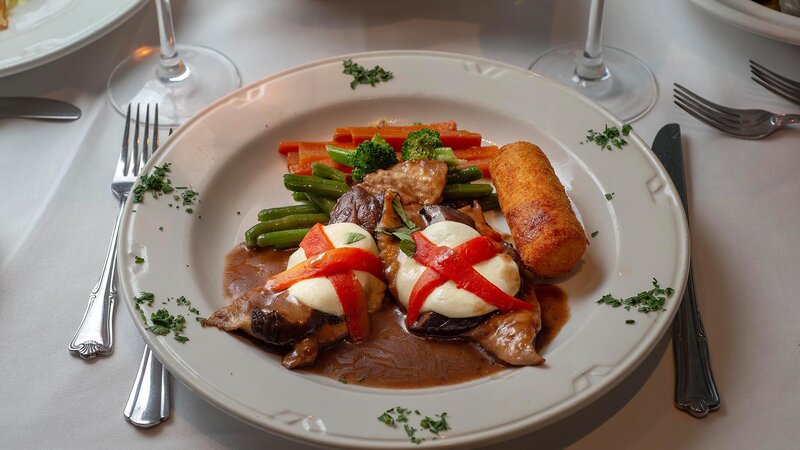 Veal entree topped with mozzarella and side of vegetables
